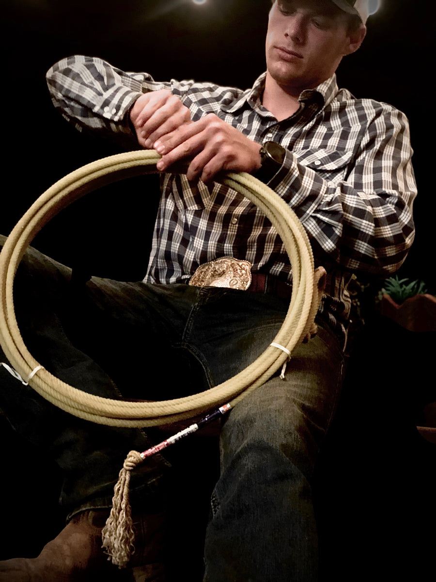 Aukina Austin Hunt in a navy palaka shirt holding a coiled rope